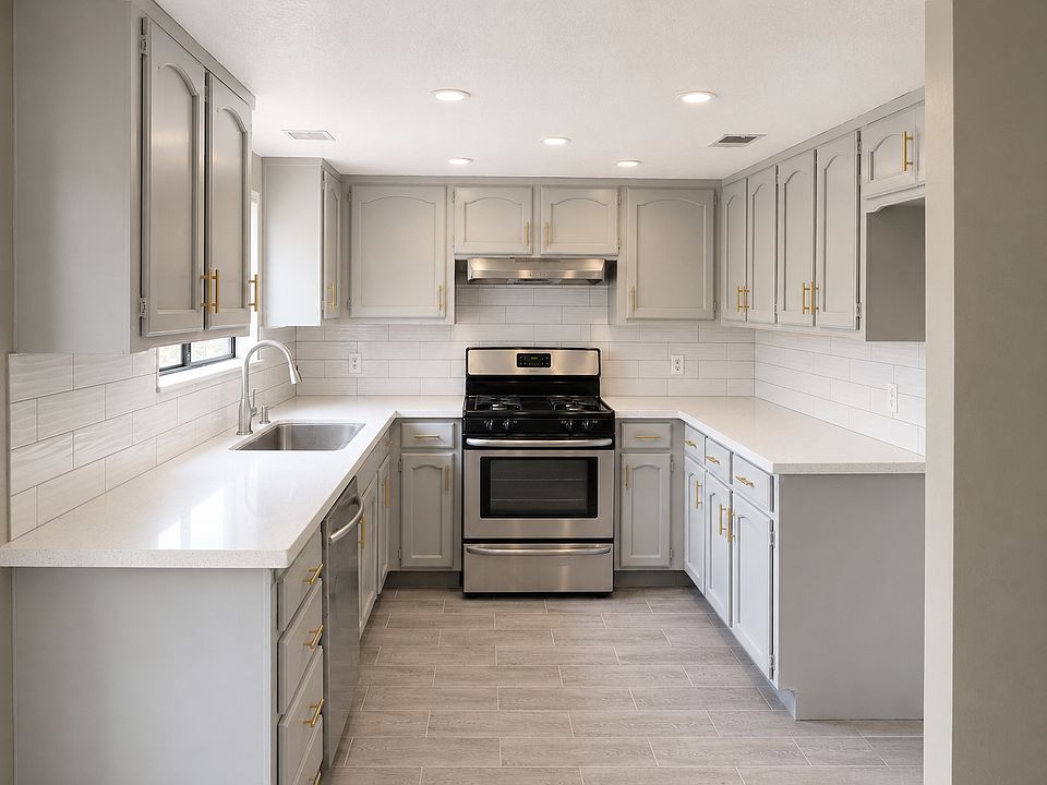 Beautifully renovated kitchen featuring a new stainless steel stove, stainless steel dishwasher, and a modern stainless steel farmhouse sink.