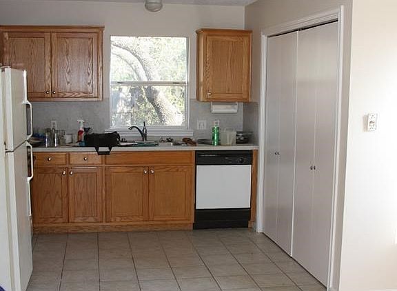 Kitchen with refrigerator, free standing stove beside refrig