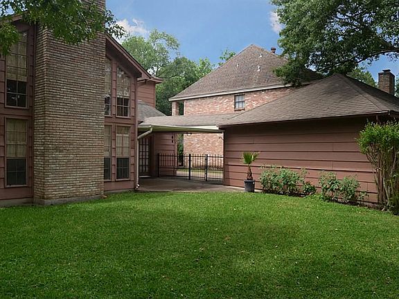 This view captures a look at the back side of the masonry brick fireplace along with the covered bac
