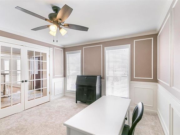 Living Room or Main Level Office with glass French doors, wainscoting, crown molding.  So light and bright!