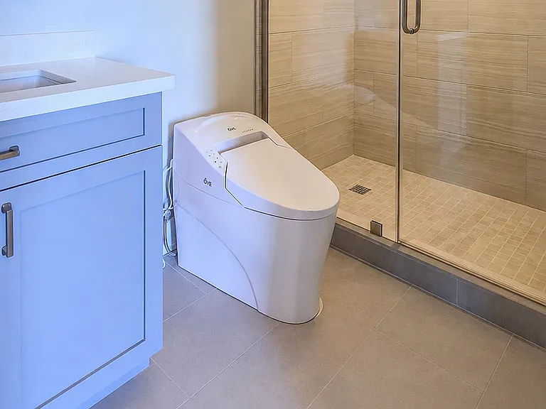 Modern bathroom with glass shower and integrated bidet toilet