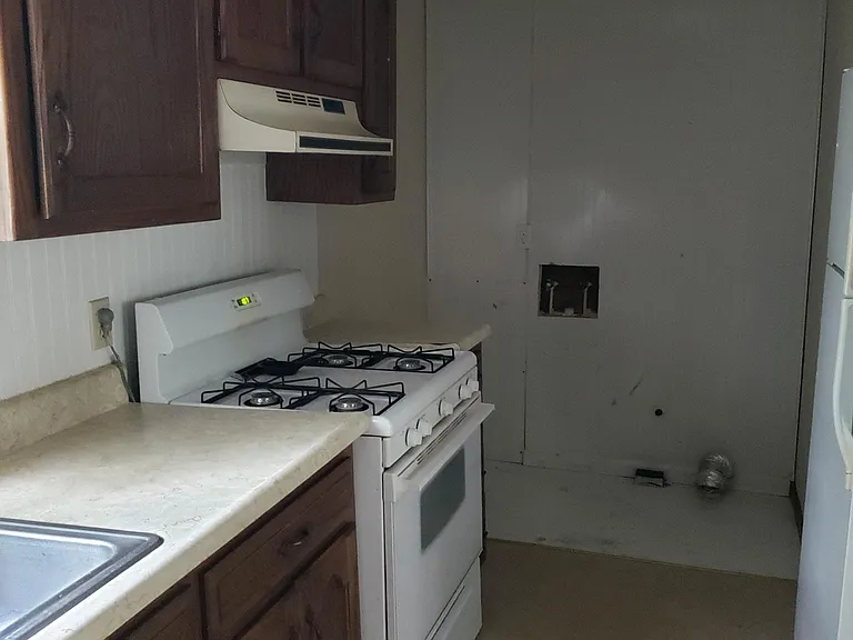 Kitchen showing washer and dryer hookups. Gas cook stove.