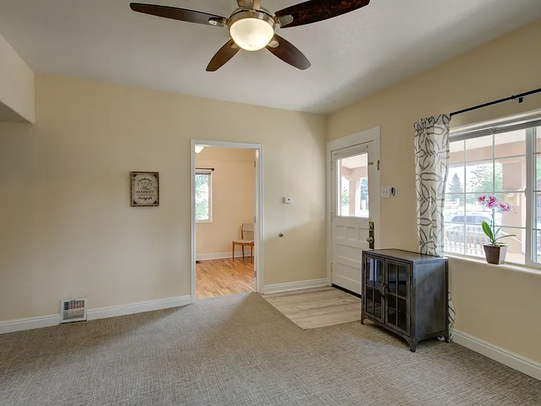 Living room with ceiling fan. front door with bedroom #1 in background