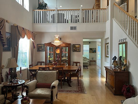 Formal living room and formal dining room with high ceilings and custom window coverings