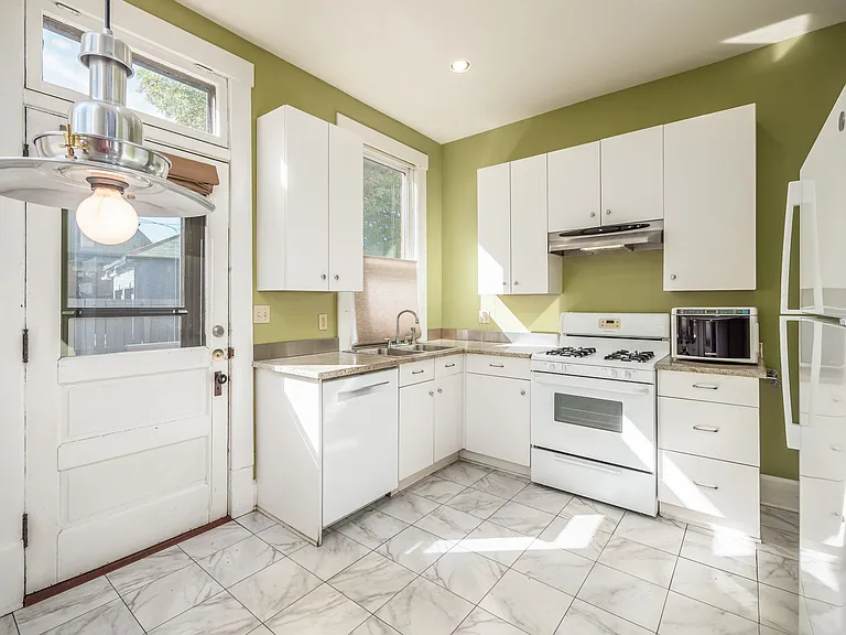 Kitchen with all white cabinetry and appliances, refrigerator is new in 2022. Paint color has been updated to neutral.