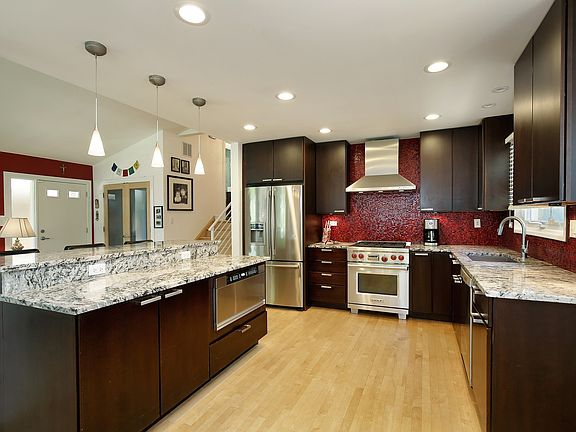 Kitchen has espresso cabinetry, granite, Italian tile backsplash & SS appliances