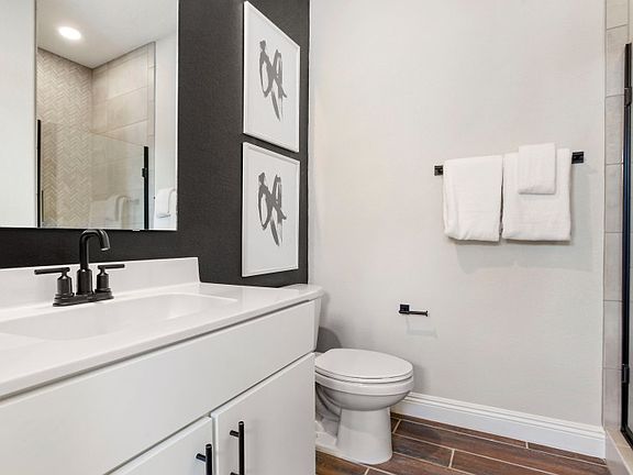 Downstairs bathroom features white marble countertops and a walk-in shower.