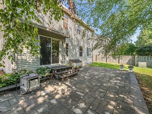Beautiful paver patio shaded by mature trees in this quiet backyard.