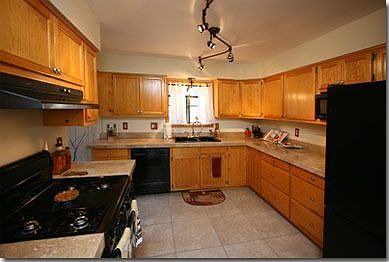 Kitchen with new travertine counter tops, porcelain tile flooring and fixtures