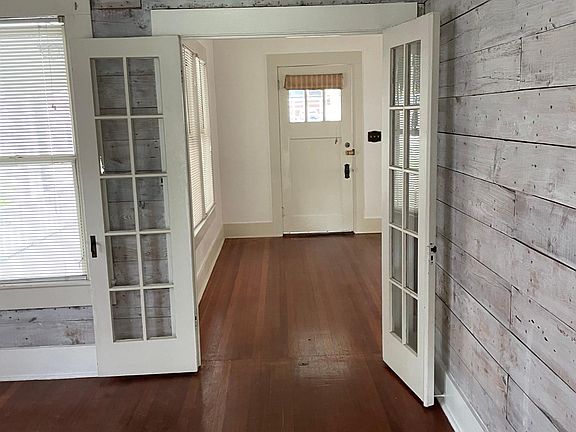 View from dining room through French doors to the living room and front door