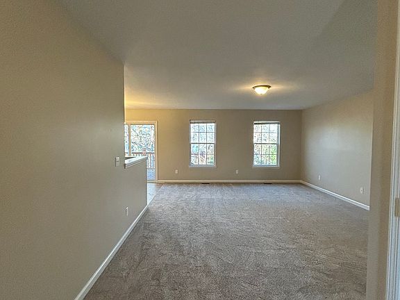 View from the front door into the living room. Hallway to bedrooms is to the right. Kitchen and dining to the left.