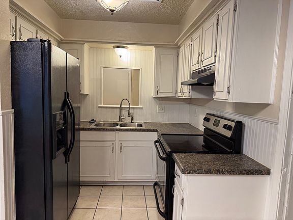 Kitchen with smooth top electric range, double sink, and refrigerator