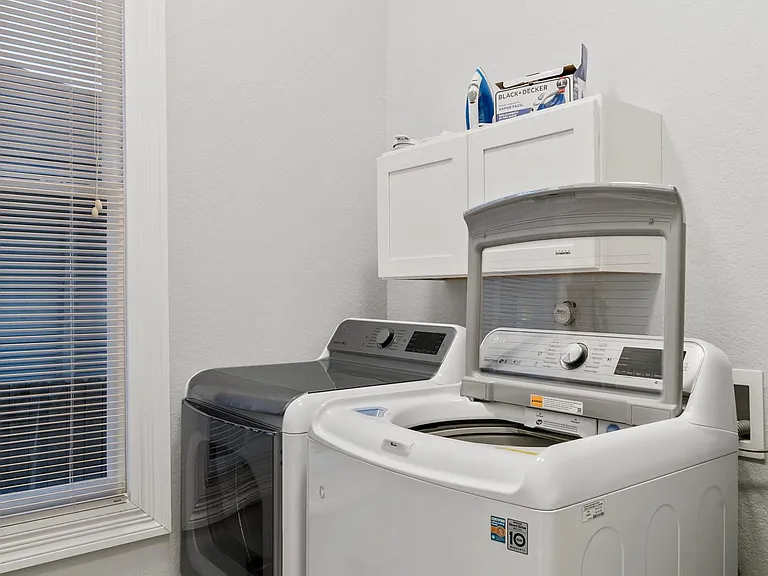 Separate utility room w/huge LG set gets laundry done fast!