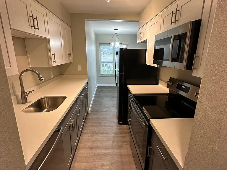 Kitchen with new quartz countertop and cabinets. Dishwasher, stove range, microwave, and big size refrigerator