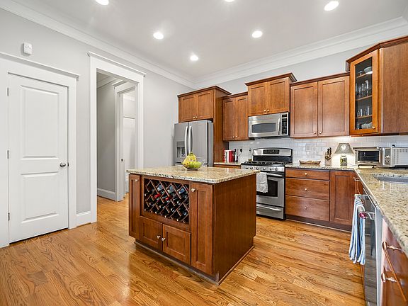 Kitchen showing pantry door and hall to main floor full bath.