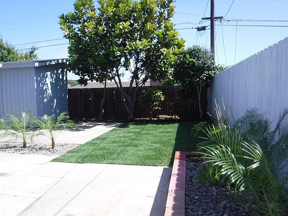 Back yard behind garage with shed on left.