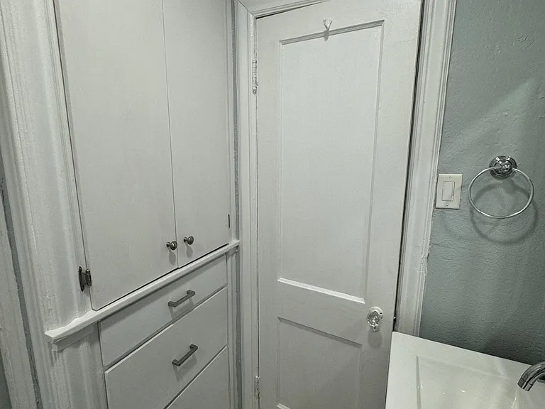 Additional storage located behind bathroom door.