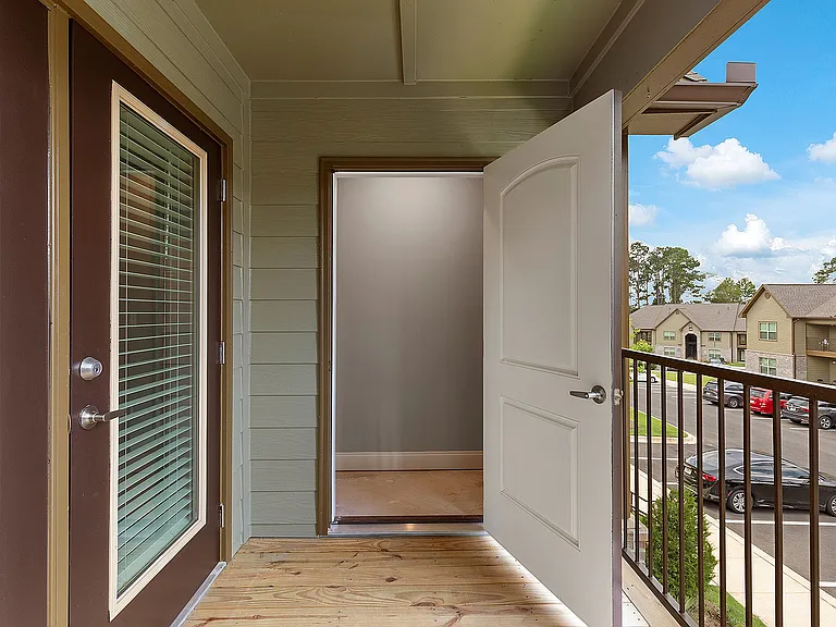 Inviting balcony entrance with a storage closet andwooden deck