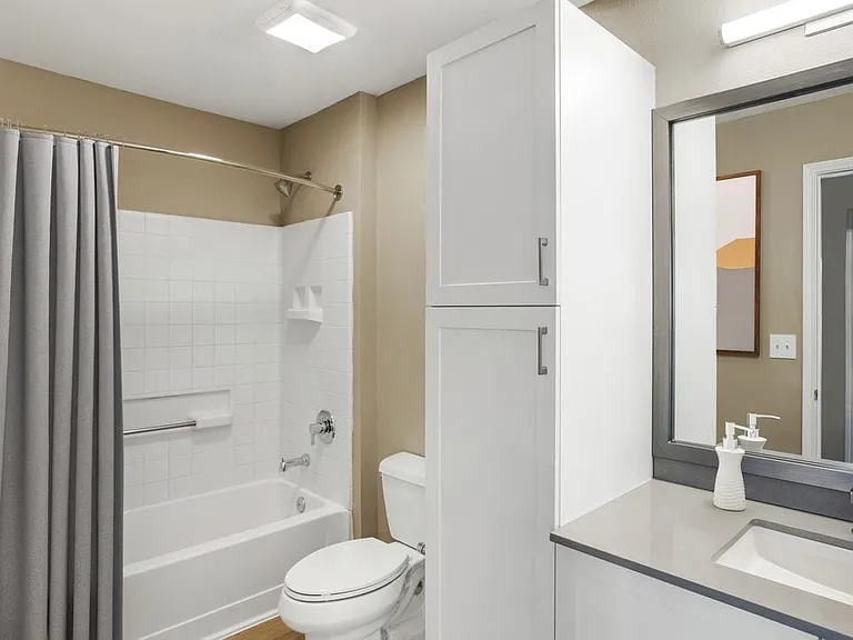 Upgrade Scheme II bath with white shaker cabinetry, grey quartz countertops, and hard surface flooring