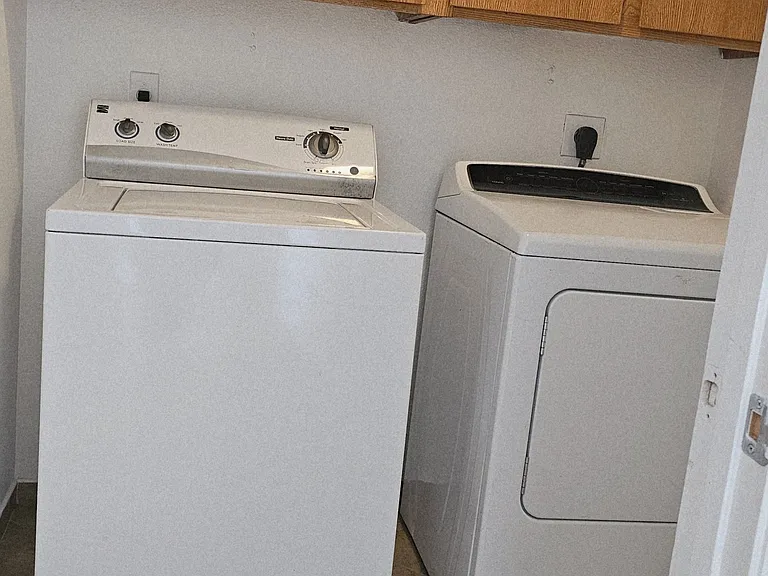 In-home laundry area with washer and dryer included, plus built-in cabinets for convenient storage.