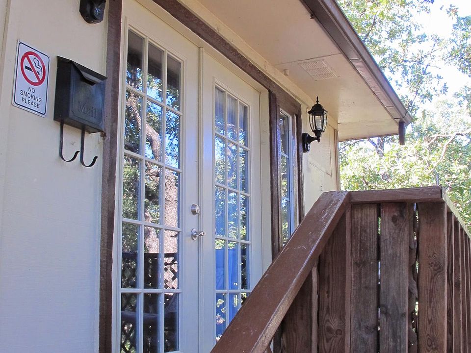 Front entrance is up a short flight of stairs, nestled in the trees.