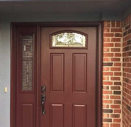 Exterior Front. This beautiful, new front door with leaded glass side light, window and peep hole on the covered front porch is so inviting.  Notice that all the cedar trim has just been painted.  Move in today and relax tomorrow.