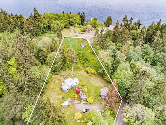 The property consists of 1.3 acres and includes the cottage, studio, plus another outbuilding and a storage shed.  It stretches past the buildings shown in the picture to the pasture below.