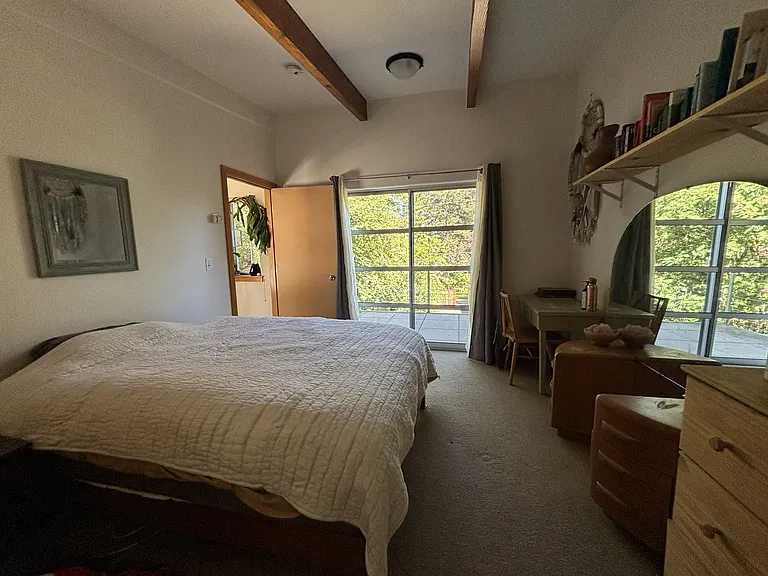 Primary bedroom upstairs: Large bedroom with a large attached bathroom. The east-facing upstairs balcony provides wonderful morning sun, lots of natural light, an afternoon shade spot, and a perfect breeze in the bedroom on summer nights.