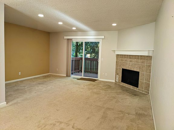 Large living space with gas fireplace opens to deck.