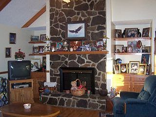 The stone wood-burning fireplace adds warmth and charm to the living room.