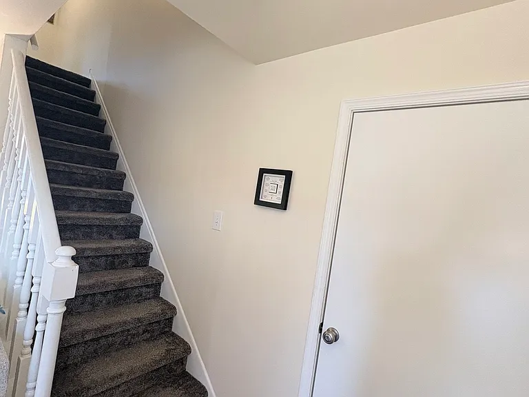 Stairs leading to upstairs bathrooms with full laundry closet.
