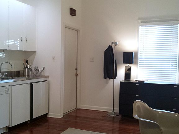 ENTRANCE DOOR INTO LIVING ROOM WITH GALLEY KITCHEN, WINDOW OPENS TO THE LANE.