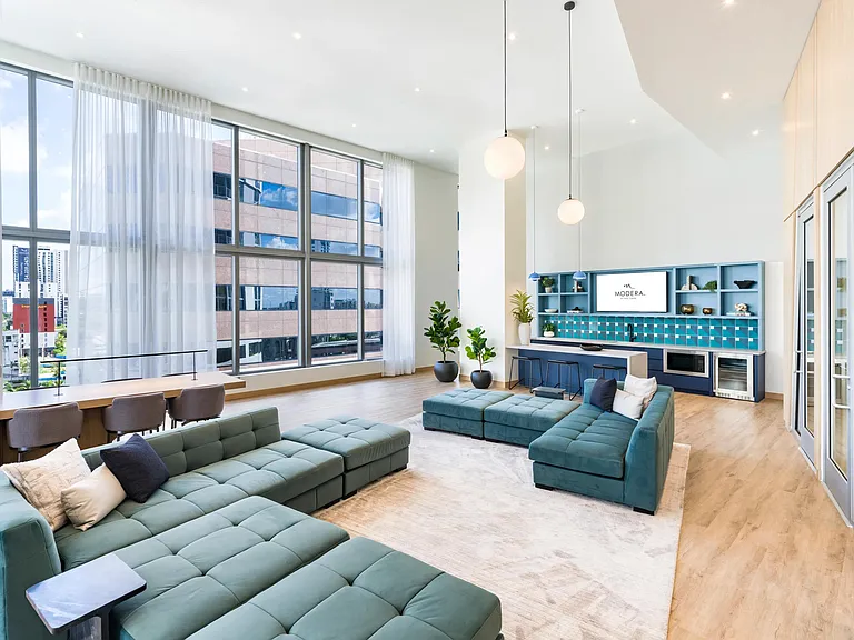 Floor-to-ceiling windows and vibrant design make Modera Riverside's lounge and coworking space the perfect place to gather in Miami.