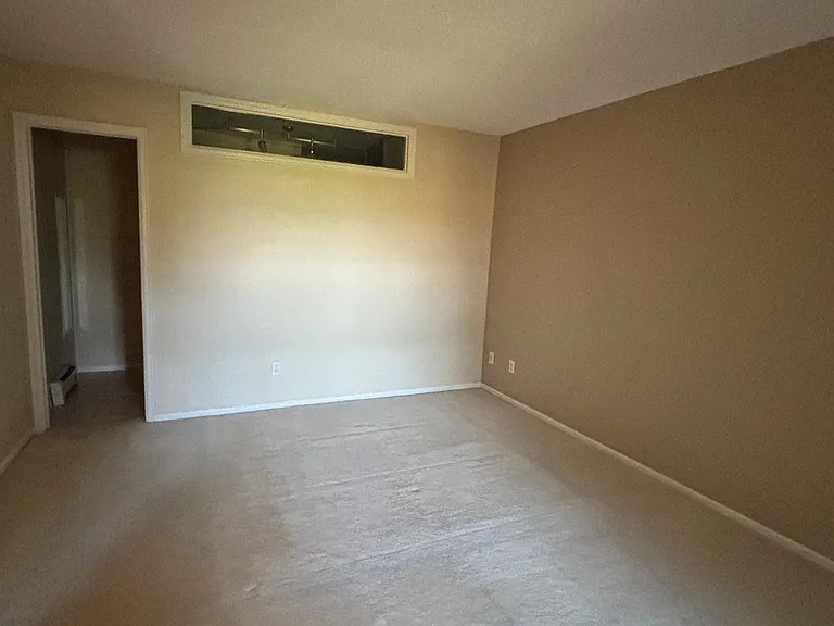 main bedroom without furniture showing door to main bathroom