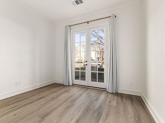 Formal living, dining, or office space with ceiling fan, blackout curtains, and French doors leading to front patio.