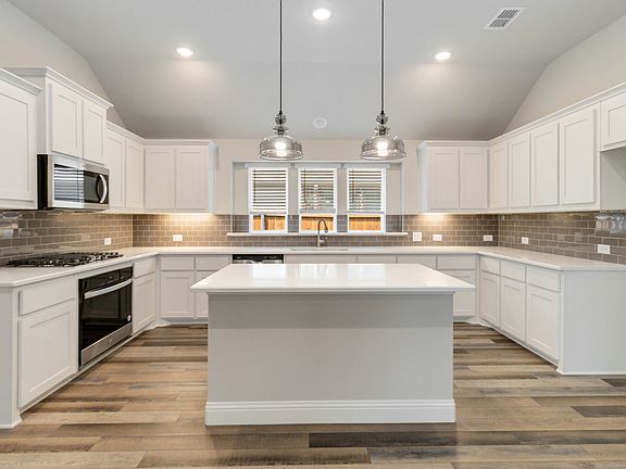 McKinney floor plan featuring open-concept living, three bedrooms, two bathrooms, and a covered pati