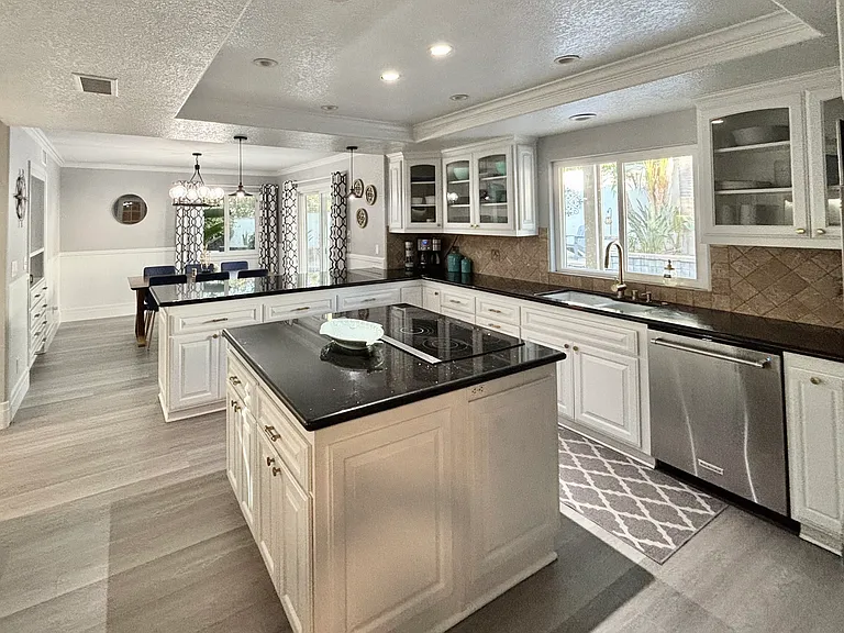 Chef's kitchen with refrigerator, dishwasher, oven, electric stovetop, garbage disposal, and coffee maker