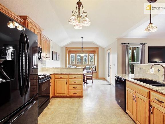 Kitchen features newer appliances, granite counters, raised counter area perfect for stools/sitting and adjoins eat-in area with window seat/nook.  Door leads to covered patio and back yard.