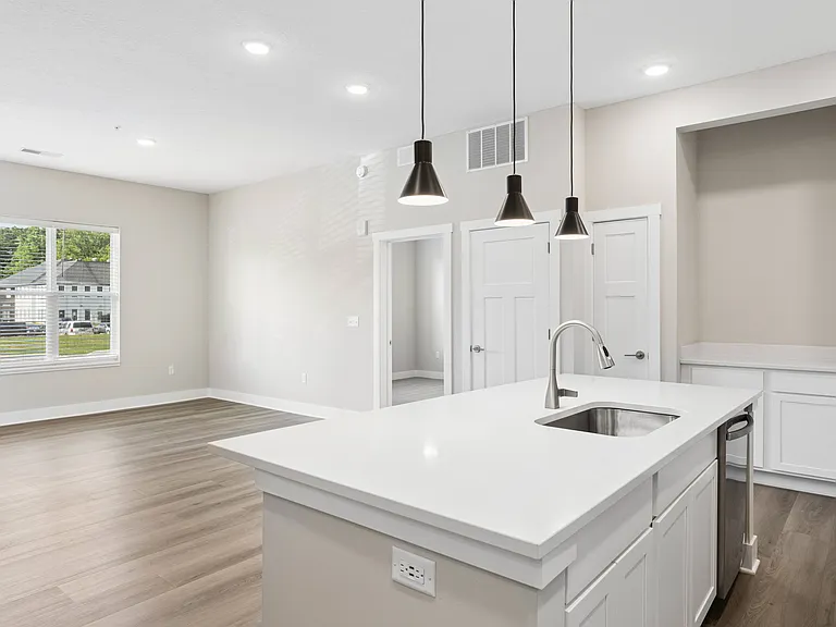 Kitchen with appliances and living area of an apartment home at Tiffany Flats in Columbus, OH.