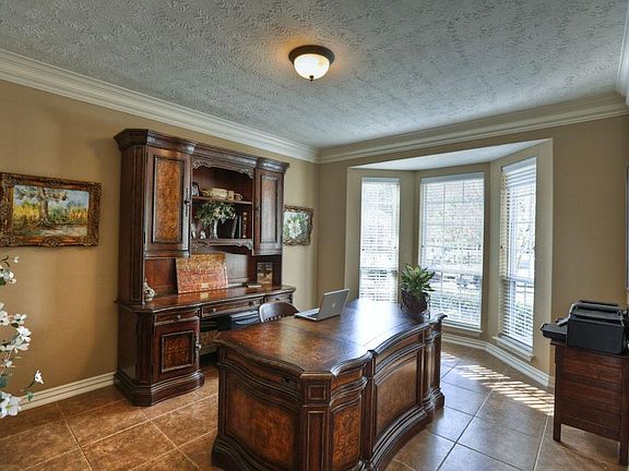 There are five bay windows and lots of crown molding. Built by Emerald Homes. Study or formal living room in this picture.