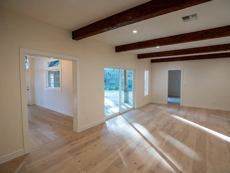 Dining room leads to the den or 2nd family room. High ceilings and exposed beams maximize the space. Could be a play room for the kids of keep the front room as a formal sitting room and this for enjoying your favorite show. Your choice! Lots of options.