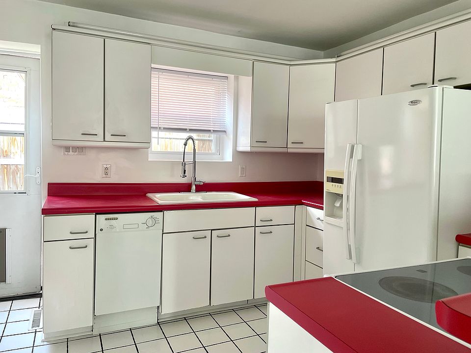 Sunny retro kitchen with new appliances and a door to the back patio.