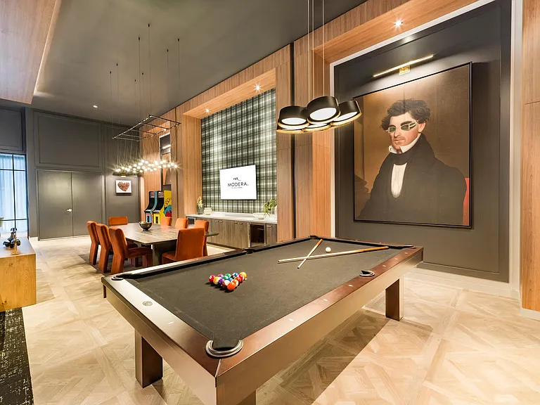 Warm wood detailing, tailored lighting, and curated artwork frame this billiards lounge, blending classic game-room elements with a polished, contemporary aesthetic.
