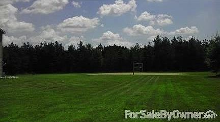 Yard : Sand volleyball court in large open yard.