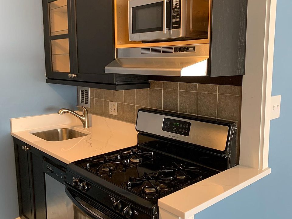 Beautifully renovated kitchen; opened up wall to living room, new quartz countertops throughout, new cabinetry and modern kitchen with full size stainless appliances