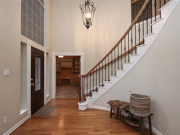 Enter into this impressive two-story foyer with rich hardwood flooring, updated lighting, and elegant wrought-iron spiral staircase. To the left of the front entrance is an ideally situated study/library for those who work at home full-time.