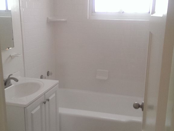bath with new tiles, sink, mirrored cabinets