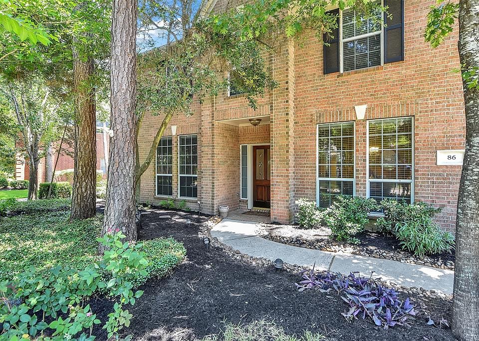 This elegant home is screened from the street by mature landscaping and shade trees.