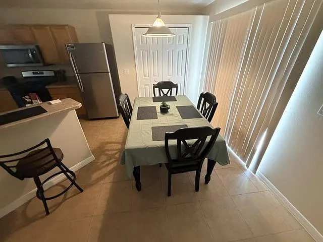 Dedicated dining area with a full-size table and seating for four, set beside sliding doors and next to the kitchen.