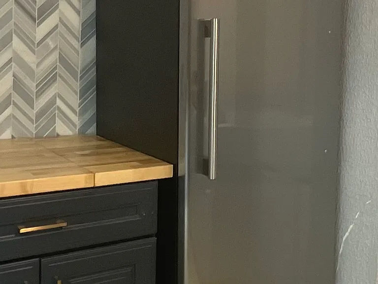 Stainless steel refrigerator. There is a large chest-freezer as well.